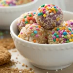No-bake cheesecake balls recipe with cream cheese, graham cracker crumbs, and powdered sugar served on a white dish.