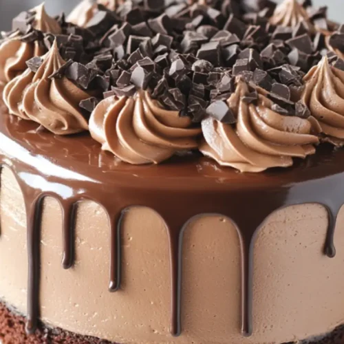 Triple chocolate fantasy cake with mousse layers, chocolate ganache drip, and decorative swirls topped with chocolate chunks.