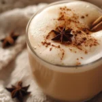 Hot chai tea latte in a clear mug with foamy top and cinnamon dusting for a chai tea latte recipe.