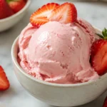 Strawberry Cottage Cheese Ice Cream scooped in a bowl with fresh strawberries, creamy high-protein homemade dessert.