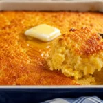 Creamy golden cornbread casserole served warm from a baking dish